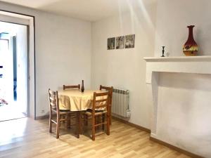 a dining room with a table and chairs and a fireplace at Appartement T3 agréable à Bourbon l'Archambault in Bourbon-lʼArchambault