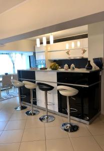 a kitchen with a counter with bar stools in it at Federal Luxury in Drobeta-Turnu Severin