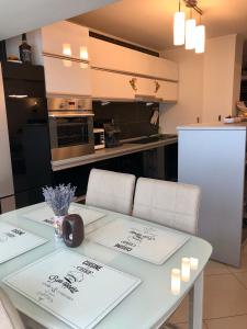 a kitchen with a white table with chairs and a kitchen with a counter at Federal Luxury in Drobeta-Turnu Severin