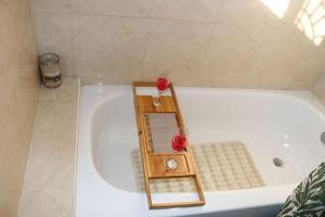 a white bath tub with a mirror in it at The Royal View (Fully AC) in Banbury