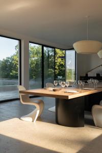 ein Esszimmer mit einem Tisch und Weingläsern darauf in der Unterkunft Villa Léonard in Saint-Étienne-la-Thillaye