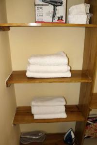 a stack of towels on a shelf in a bathroom at The Royal View (Fully AC) in Banbury