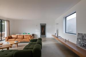 ein Wohnzimmer mit Sofa und Fernseher in der Unterkunft Villa Léonard in Saint-Étienne-la-Thillaye