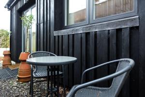 a patio with two chairs and a table and a window at South Downs Studio - bijou hikers hideaway in Old Town
