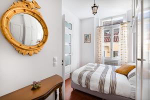 Schlafzimmer mit einem Bett und einem Wandspiegel in der Unterkunft Athenian Getaway Villa in Plaka with Acropolis View by Athenian Homes in Athen
