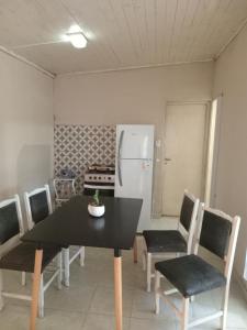 a dining room with a table and chairs and a refrigerator at ML in Navarro +2 photos