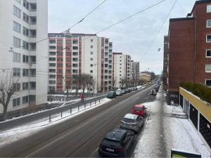 uma rua nevada com carros estacionados nela em FyraRumOasen em Gotemburgo