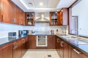 a kitchen with wooden cabinets and stainless steel appliances at WeHost - Modern 1BR Close to Burj Khalifa and Dubai Mall in Dubai