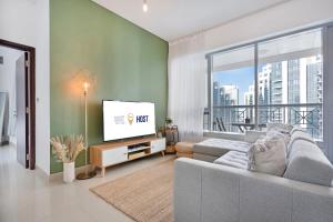a living room with a couch and a flat screen tv at WeHost - Modern 1BR Close to Burj Khalifa and Dubai Mall in Dubai