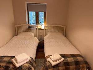 2 camas individuales en una habitación con ventana en Roundstone Home with a Harbour and Mountain View, en Roundstone