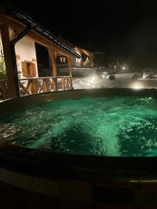 a hot tub in front of a house at night at Na widoku- domki Bukowiec in Bukowiec