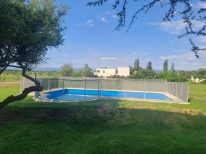 una valla alrededor de una piscina en un patio en Casa Carlos Paz en Country Causana en Villa Carlos Paz