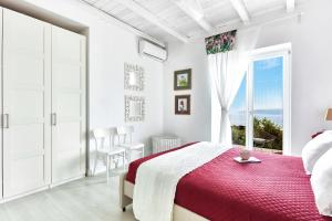 a white bedroom with a bed and a large window at Luxury villa in Kechria in Kechria
