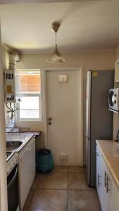 cocina con nevera blanca y puerta en Casa Nueva en Condominio Tranquilo en Osorno