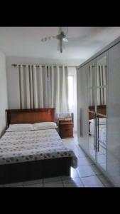 a bedroom with a bed and a ceiling fan at Apartamento praia de Camburi in Vitória