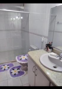 a bathroom with a sink and a toilet and a mirror at Apartamento praia de Camburi in Vitória