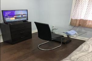 a bedroom with a glass desk and a chair and a tv at Cozy Delux-Shay-101 in Pickering