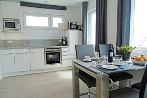 a kitchen with a table with chairs and a dining room at Strandkrabbe in Olpenitz