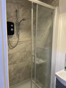 a shower with a glass door in a bathroom at Three En-Suit Rooms in Manchester