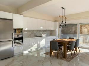 una cucina con tavolo, sedie e frigorifero di Andreas Maisonettes and Apartments a Nikiti