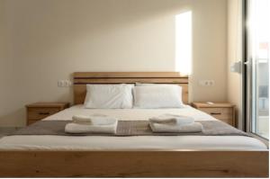 尼基季的住宿－安德烈亞斯複式小屋和公寓，一间卧室配有一张床,上面有两条毛巾
