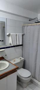 a white bathroom with a toilet and a sink at Departamento Tipo Estudio Dynasty Isla de Margarita in Porlamar