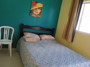 1 dormitorio con 1 cama con una chica pintando en la pared en Pousada Vista Verde en Paracuru