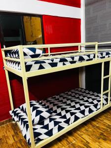 a bunk bed with a black and white checkered floor at Hostel kuruku santhu colive in Pondicherry