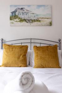 1 cama con almohadas amarillas y una foto de playa en Flatzy - Modern 3 Bedroom Home in City Centre, en Liverpool