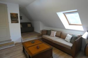 ein Wohnzimmer mit einem Sofa und einem Fenster in der Unterkunft Chez Valérie in Merlevenez