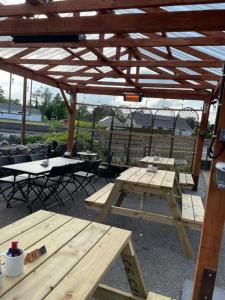 a picnic table and benches under a wooden pavilion at The Yeats County Inn Hotel in Tobercurry