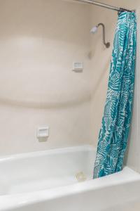 a bathroom with a bath tub with a blue shower curtain at Samesun San Francisco in San Francisco