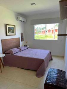 Schlafzimmer mit einem großen Bett und einem Fenster in der Unterkunft Condomí. Praia da Pérola -Beira Mar-Ilhéus/Itacaré in Ilhéus