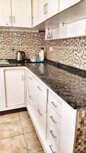 a kitchen with white cabinets and black counter tops at Lavalle II in Venado Tuerto