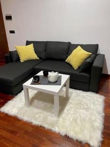 sala de estar con sofá negro y mesa de centro blanca en Appartamento con WI FI e Netflix Your second House, en Volla