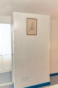 a white wall with a picture of a horse on it at Beautiful 3-Bed Cottage in Burnham-on-Crouch in Burnham-on-Crouch