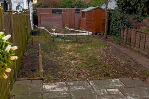 a backyard with a fence and a garden at Beautiful 3-Bed Cottage in Burnham-on-Crouch in Burnham-on-Crouch