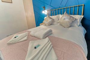 un letto con due asciugamani e cuscini sopra di Beautiful 3-Bed Cottage in Burnham-on-Crouch a Burnham-on-Crouch