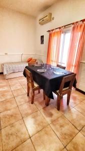 uma sala de jantar com uma mesa e cadeiras e uma cama em Lavalle II em Venado Tuerto