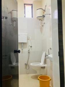 a bathroom with a toilet and a shower and a sink at Oceanic Stay And Restaurant Gokarna in Gokarn