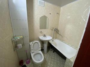 a bathroom with a toilet and a sink and a tub at Jasper Hotel in Darhan