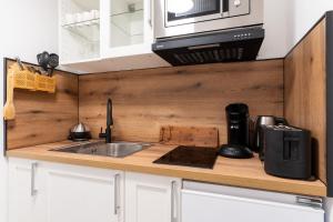 a kitchen counter with a sink and a microwave at Ferienhaus The Himmelsteig in Sasbachwalden