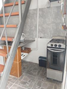 małą kuchnię z kuchenką i schodami w obiekcie Departamento temporario en cordoba w Córdobie
