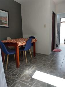jadalnia ze stołem i niebieskimi krzesłami w obiekcie Departamento temporario en cordoba w Córdobie