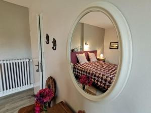 Schlafzimmer mit einem Bett und einem großen Spiegel in der Unterkunft Manoir du Taillis in Heugon