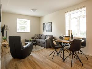 uma sala de estar com um sofá e uma mesa em Barn24 - The Stable & The Loft em Roggel