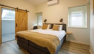 a bedroom with a large bed and a door at Barn24 - The Stable & The Loft in Roggel