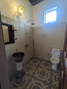 ein Bad mit einem WC und einem Waschbecken in der Unterkunft Cwmbale Eco-Safari Lodges, Restaurant and Zoo. in Mbale