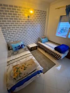 a bedroom with two beds and a brick wall at Family house in the center of fez in Fez