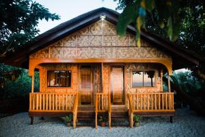 a log cabin with a porch and two windows at Nana's Beach Surigao in Surigao